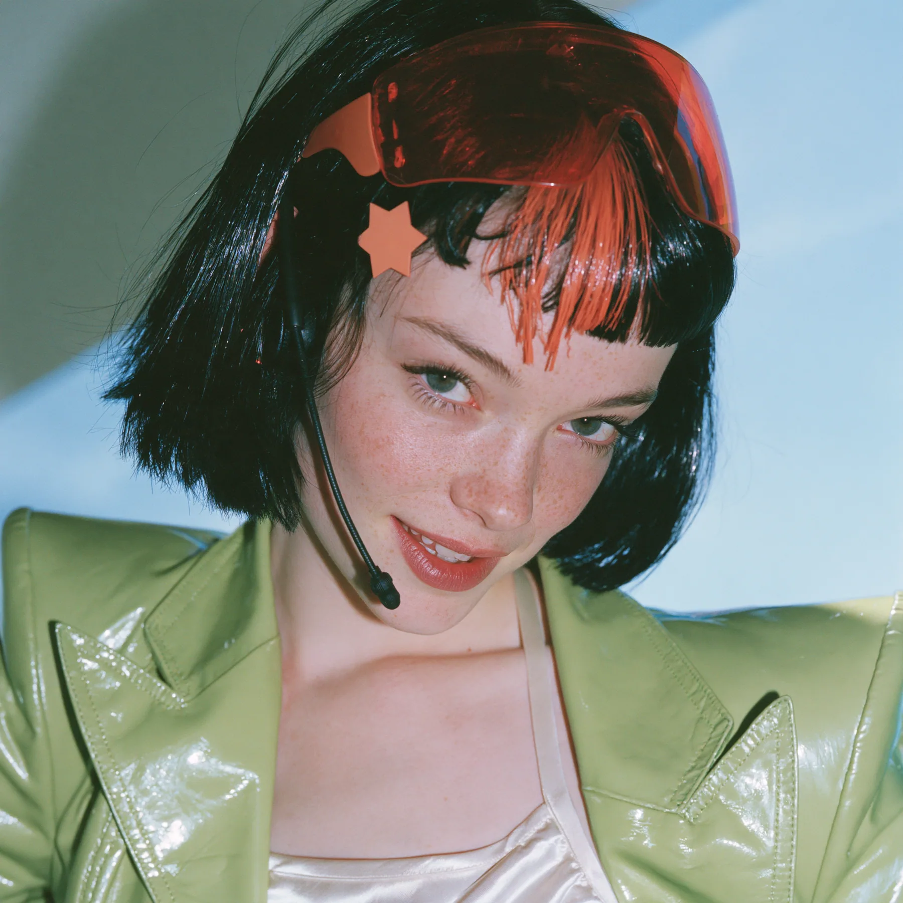 Y2K high fashion editorial, a 2001 couture magazine story: a square beauty portrait of a Caucasian American woman in her mid-twenties with pale skin and light freckles, a glossy black blunt jaw-length bob with heavy…