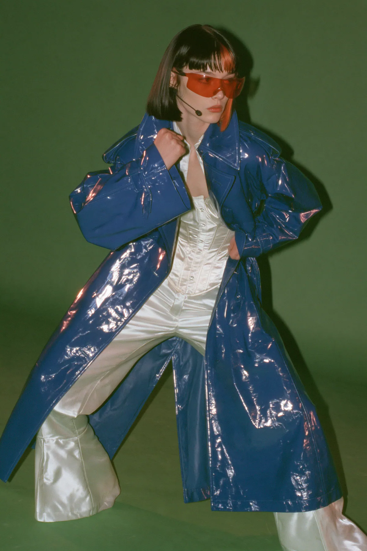 Y2K high fashion editorial, a 2001 couture magazine story: full-length shot, head to toe with the feet in frame, of a young Caucasian American woman with pale skin and a glossy black blunt bob with heavy straight…