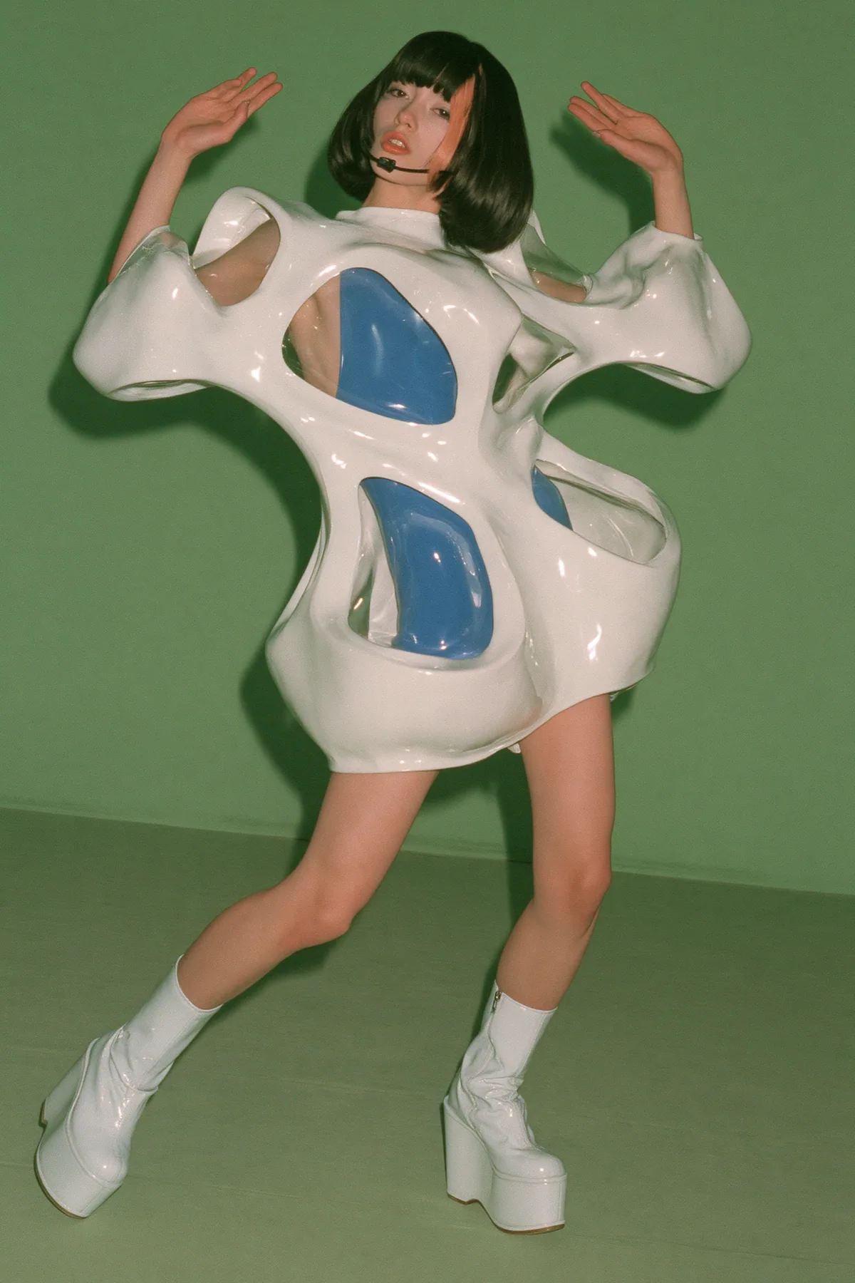 Y2K high fashion editorial, a 2001 couture magazine story: full-length shot, head to toe with the feet in frame, of a young Caucasian American woman with pale skin and a glossy black blunt bob with heavy straight…