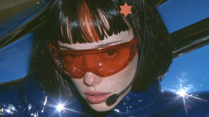 Y2K high fashion editorial, a 2001 couture magazine story: a Caucasian American woman in her mid-twenties with pale skin and light freckles, a glossy black blunt jaw-length bob with heavy straight bangs and one…